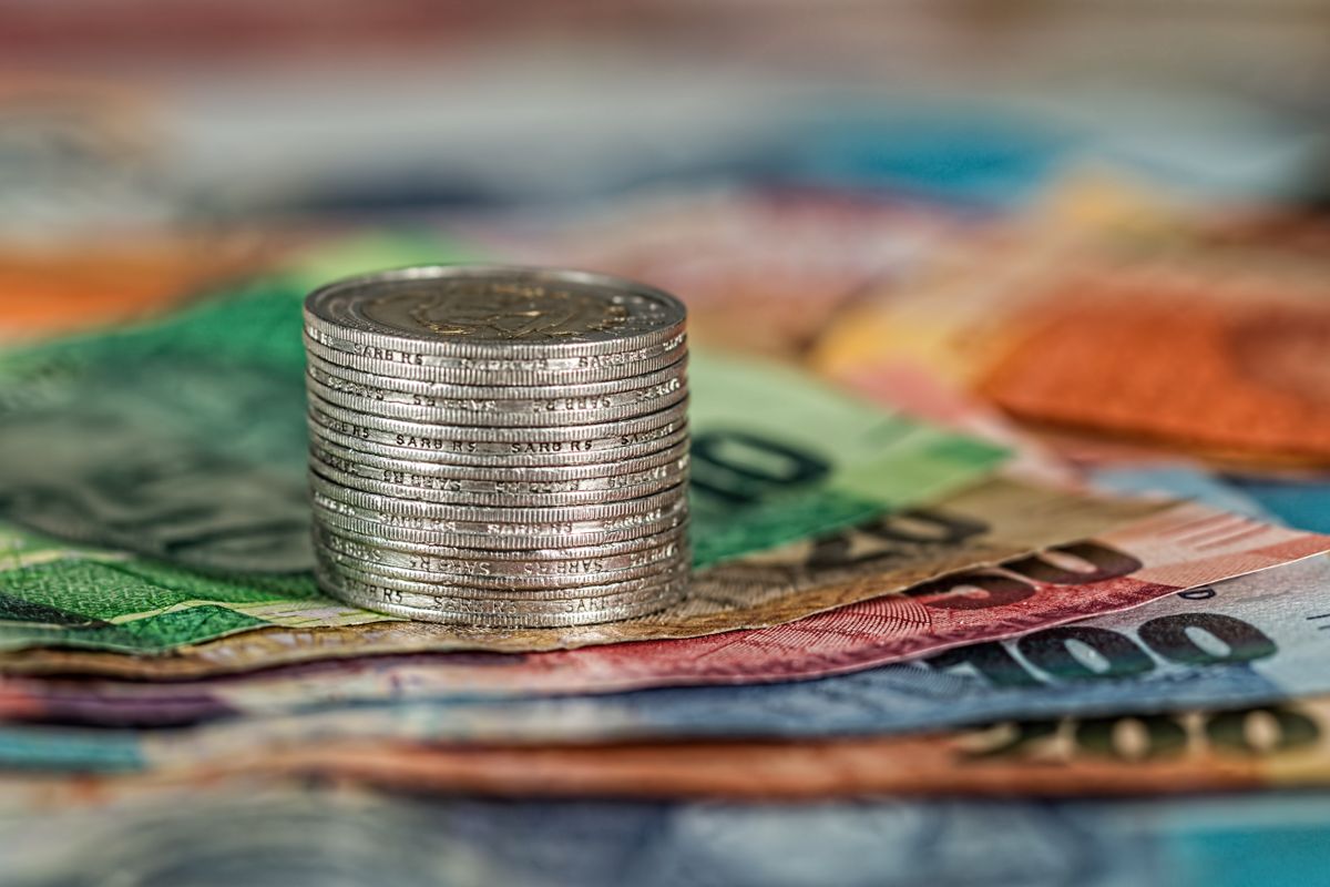 Mince a bankovky jako symbol skryté ceny ručních zápisů