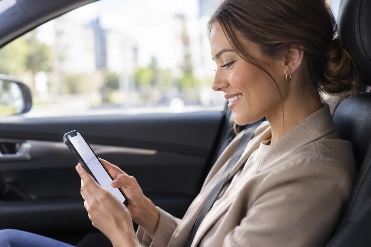Poradkyně v autě kontroluje hotový záznam z jednání v telefonu